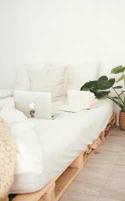 white bed with a laptop on top