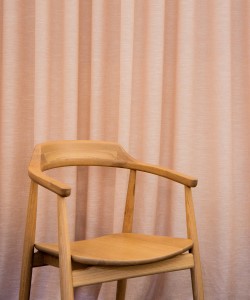 wood chair with salmon curtains