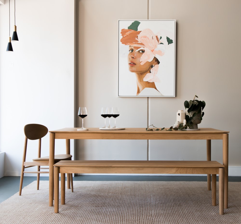 wood table with wine glasses on top and picture in the wall